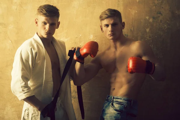 Atletiska män tvillingar i karate kimono och boxning handskar — Stockfoto