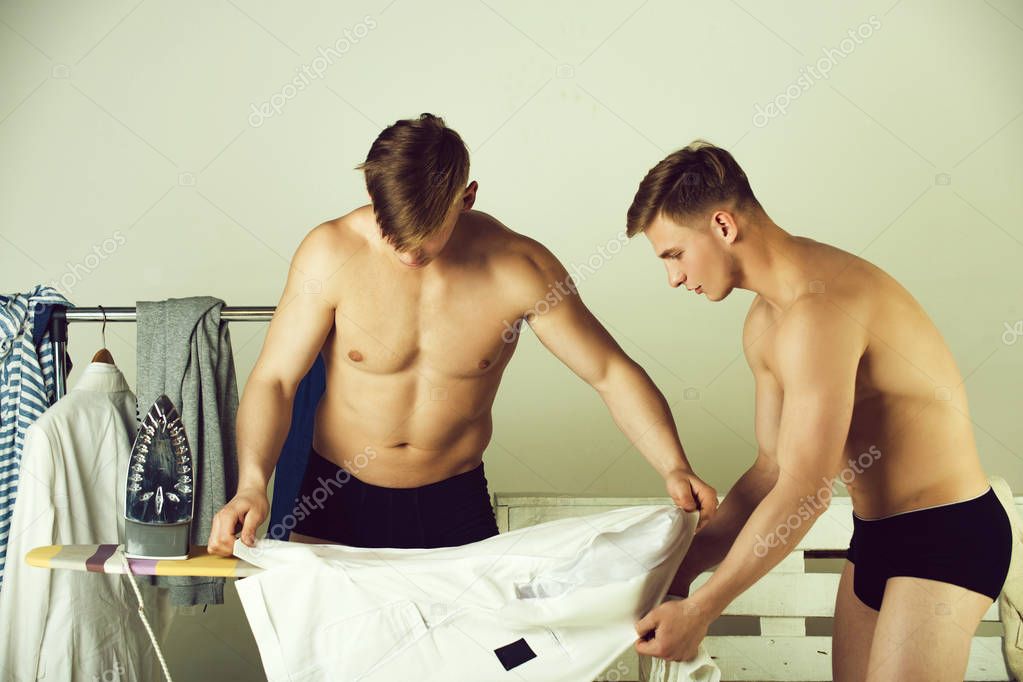 Men ironing shirts together — Stock Photo © 186401728