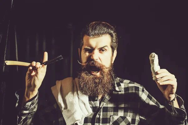 大胡子的男人用剃须刀刮胡子 — 图库照片