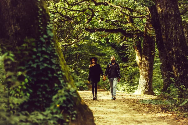Fashionable couple in green forest — Stock Photo, Image