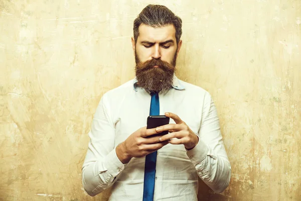 Liikemies tai parrakas mies, jolla on pitkä parta puhelimessa — kuvapankkivalokuva