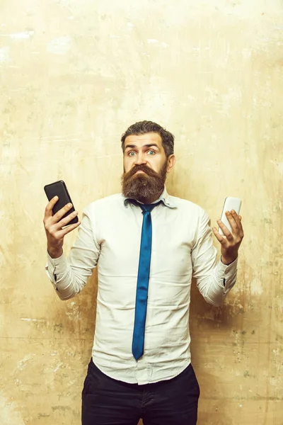 Hipster veya sakallı adam karşılaştırmak hareket eden telefon ve smartphone — Stok fotoğraf