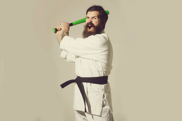 Bearded shouting karate man in kimono with green baseball bat — Stock Photo, Image