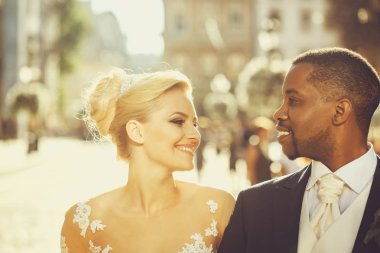 Mutlu Afrika kökenli Amerikalı damat ve sevimli gelin sokakta yürüme