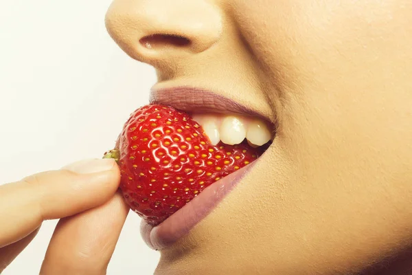 Labios femeninos comiendo fresa roja — Foto de Stock