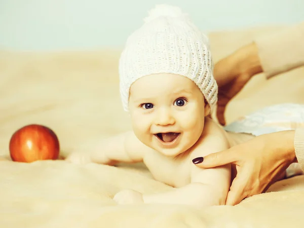 Baby boy in white hat and with red apple — Stock Photo, Image