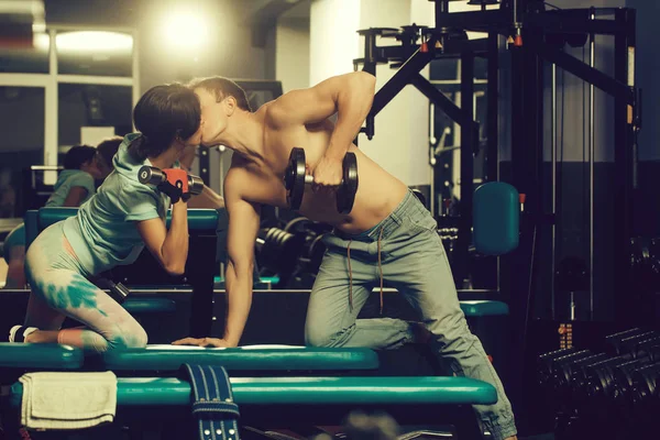 Muskulös man och flicka på gym med hantlar — Stockfoto