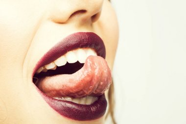Kadın açık gülümseyen ağız seksi dudaklar mor ruj ve dil ile