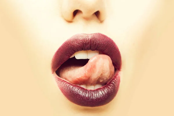 女性张开嘴用性感的嘴唇紫色唇膏和舌头上米色背景 — 图库照片