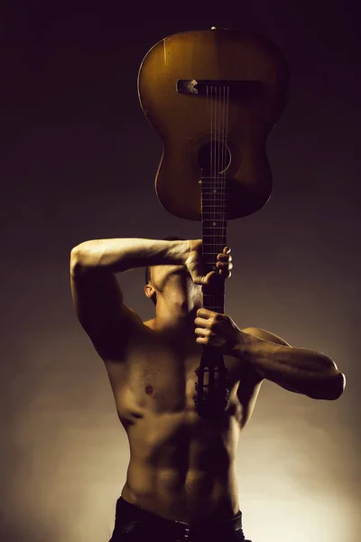 Sexy muscular homem com acústico guitarra — Fotografia de Stock