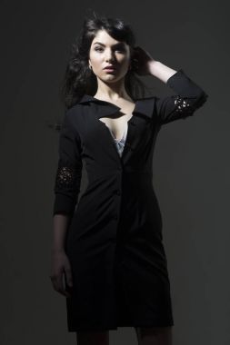 Esmer saçlı seksi Bayan siyah elbise giyer.