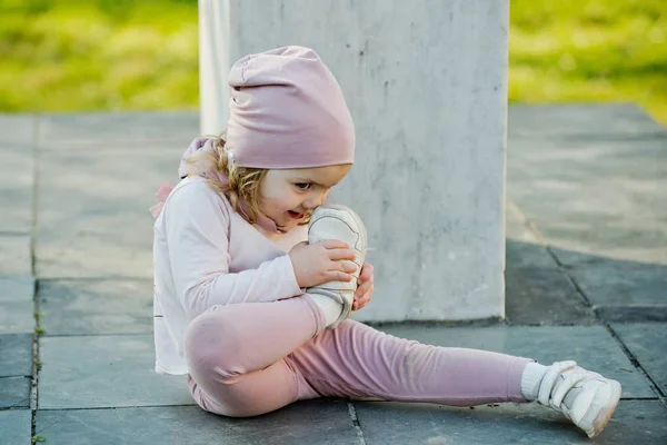 Menina de chapéu rosa, roupas nariz toque com sapato esporte — Fotografia de Stock