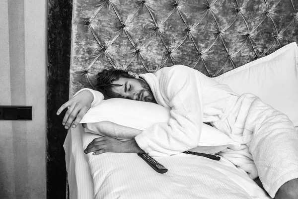 Sakallı adam yatakta uzaktan kumandalı — Stok fotoğraf