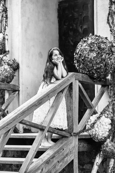 Leende flicka på trappan med blomdekor — Stockfoto