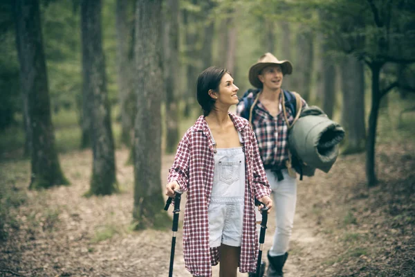 Casal apaixonado caminhadas na floresta com equipamentos turísticos — Fotografia de Stock