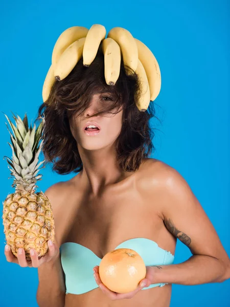 Brunetta in costume da bagno con banana, pompelmo, ananas — Foto Stock