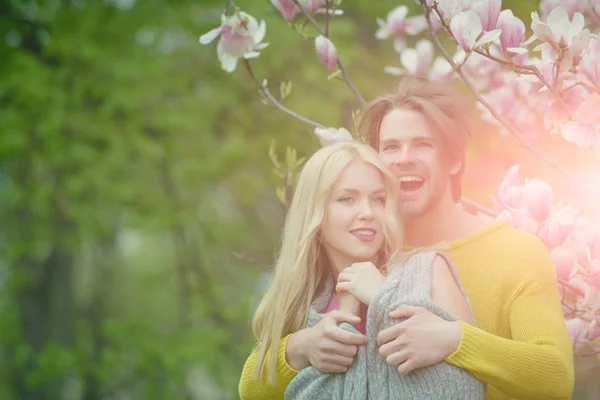 Man met meisje of mooie vrouw op bloeiende magnolia — Stockfoto