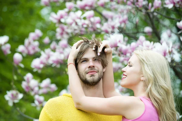 Pár v lásce v rozkvetlé květiny, jarní. — Stock fotografie