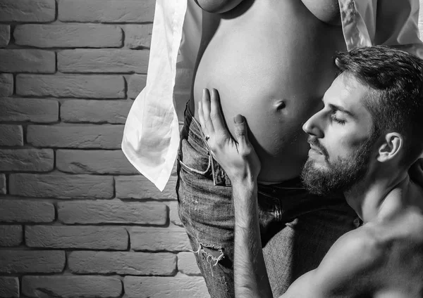 Barbudo hombre y bonita mujer embarazada con desnudo vientre redondo —  Fotos de Stock