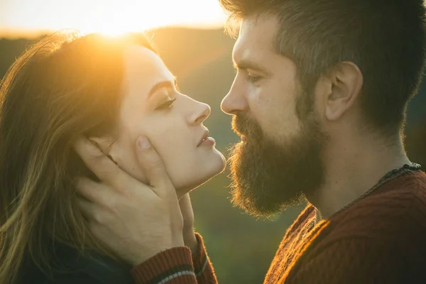 Man with beard holds womans head with tenderness