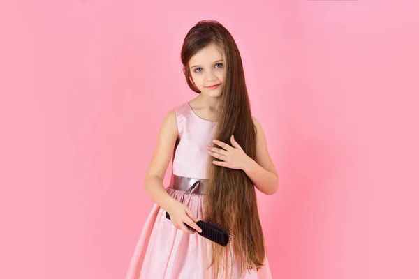Menina criança escova de cabelo em vestido elegante em rosa . — Fotografia de Stock