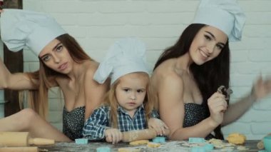 Lezbiyen çift ile onların evlat edinilmiş çocuk yemek. Kız onların kardeşi ile pişirme.