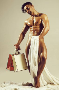 çıplak kaslı adam alışveriş torbaları ile