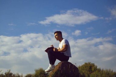 Kitap açık olan dalgın kaslı adam