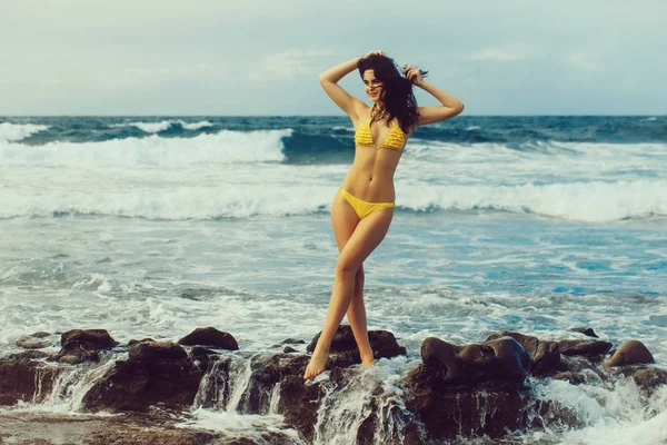 Hübsches Mädchen im sexi gelben Badeanzug steht in weißem Schaum — Stockfoto