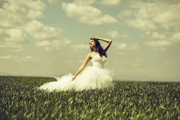 Bonita chica de la boda en hierba verde y el cielo —  Fotos de Stock