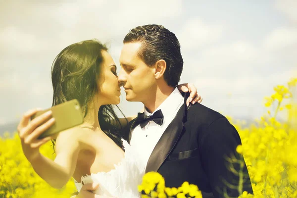 新婚夫妇在领域黄色花吻 — 图库照片