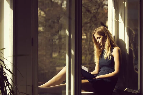 Linda chica leyendo libro en ventana abierta —  Fotos de Stock