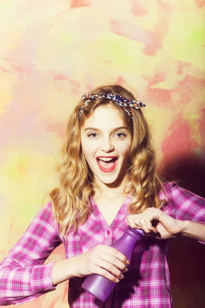 Excited pretty girl laughs with violet water bottle — Stock Photo, Image