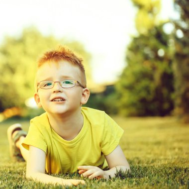 Çimenlerin üzerinde bardaklarda Kızıl saçlı erkek mutlu bebek
