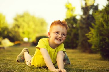 Çimenlerin üzerinde bardaklarda Kızıl saçlı erkek mutlu bebek