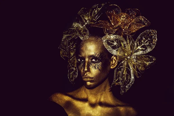 Mujer de oro con flores decorativas —  Fotos de Stock