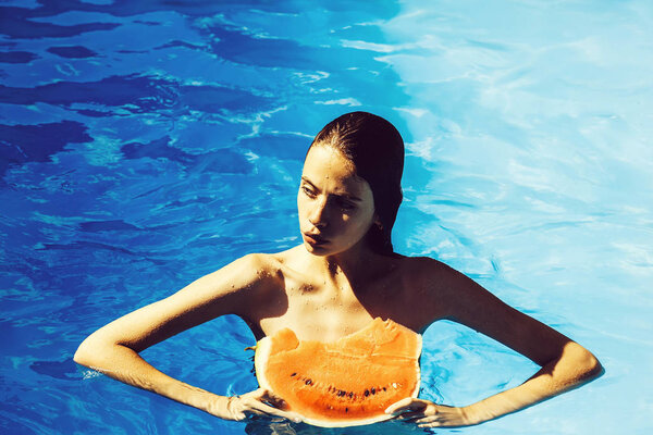 woman with watermelon in swimming pool