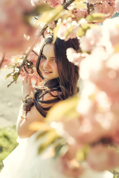 Pequeña chica sonriente en flor — Foto de Stock