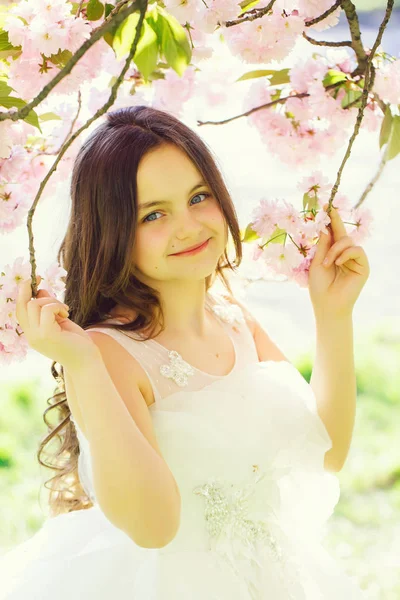 Kleine lachende meisje in bloei — Stockfoto