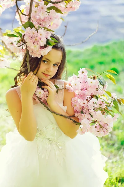 Klein meisje in de bloei van de lente — Stockfoto