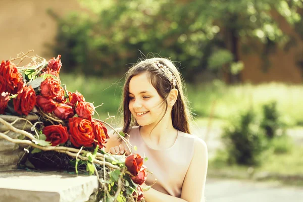 Petite fille aux roses rouges — Photo