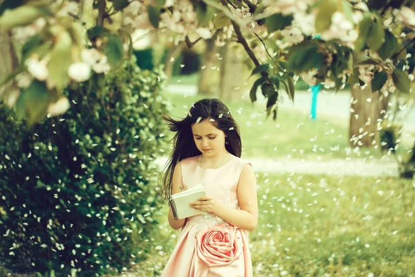 Chica en vestido con cuaderno y pluma en el jardín —  Fotos de Stock