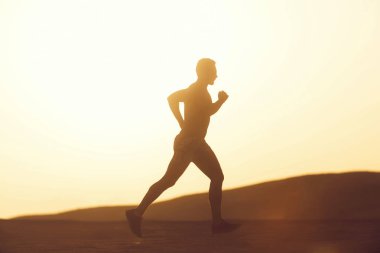 Dune günbatımında çalışan adam runner