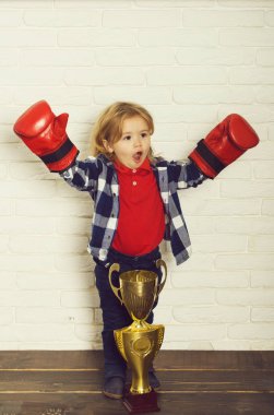 Boks eldiveni altın şampiyon kupa kazanan çocuk mutlu kazanan