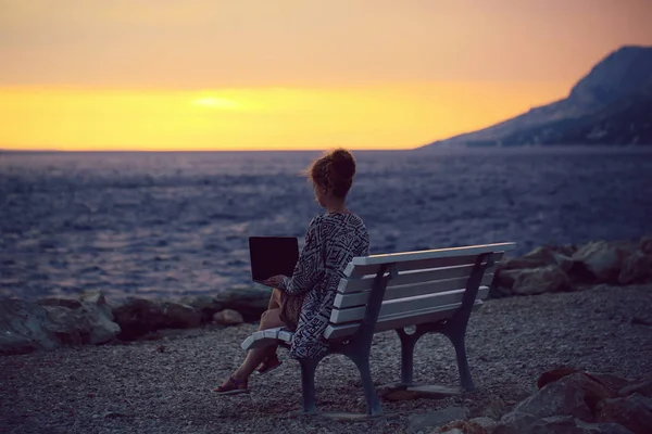 Woman with laptop on evening beach — Stock Photo, Image