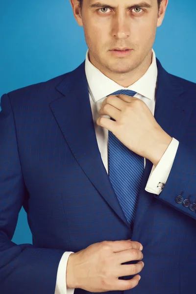 boss adjusting tie in elegant navy formal suit