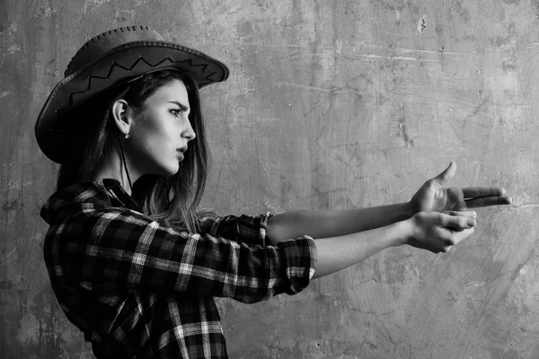 Chica bonita en elegante sombrero de vaquero que muestra la pistola de dedo —  Fotos de Stock
