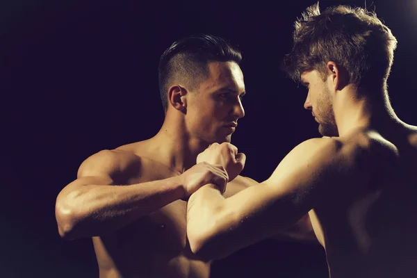 Young muscular men boxing