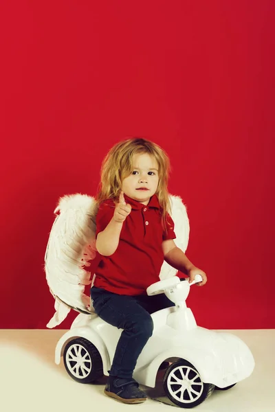 Saludo del día de San Valentín, pequeño niño ángel en el juguete del coche — Foto de Stock