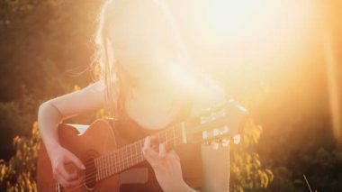Kız gitar çalmak. Parçası. Kadın Sunset'teki gitar çalmak.